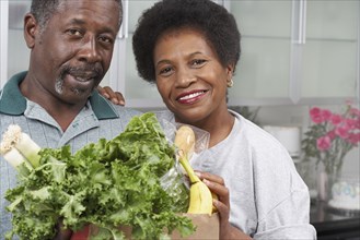 Middle-aged African American couple with groceries