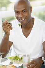 African American man eating salad