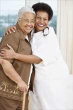 Doctor hugging senior African American woman