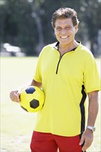 Hispanic man holding soccer ball
