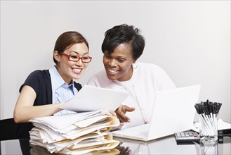 Multi-ethnic businesswomen looking at paperwork