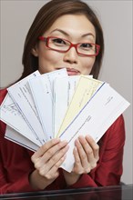 Asian businesswoman holding checks