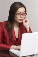 Asian businesswoman looking at laptop