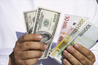 Close up of Arab man holding dollars and euros