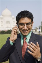 Indian businessman talking on cell phone at the Taj Mahal
