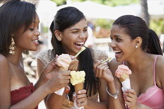Teenage friends eating ice cream cones