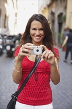 Tourist woman holding digital camera