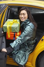 Korean woman with gifts taking taxi