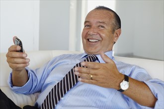 Hispanic businessman holding cell phone
