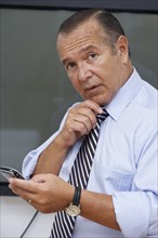 Hispanic businessman using cell phone