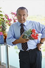 Hispanic businessman holding bouquet of flowers
