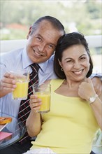 Hispanic couple drinking orange juice