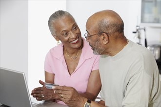 African couple shopping on internet with credit card