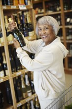 Senior African American woman buying champagne