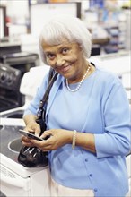 Senior African American woman text messaging on cell phone