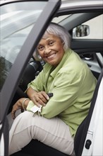 Senior African American woman sitting in driver's seat of car
