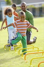 African American boy running across obstacle course