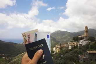 Man's hand holding passport and euro currency