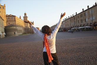 Italian woman with arms raised in piazza
