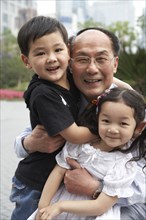 Chinese grandfather and grandchildren smiling