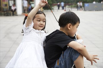 Chinese sister pulling brothers hair