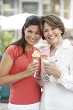 Hispanic mother and daughter enjoying ice cream cones