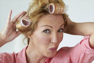 Caucasian woman putting rollers in her hair