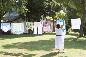Caucasian woman hanging laundry on clothes line