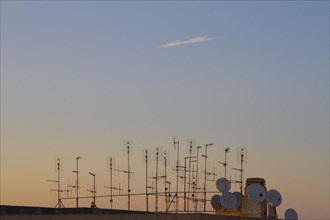 Silhouette of television antennas on rooftop