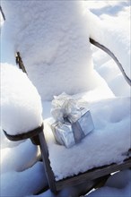 Christmas gift on chair in snow