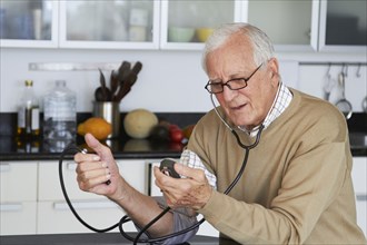 Caucasian man taking his own blood pressure
