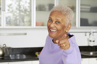 African American woman pointing in kitchen