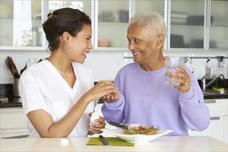 African American woman taking medication and eating lunch