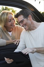 Caucasian couple using digital tablet by car