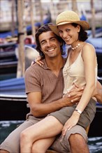 Caucasian couple sitting together near gondolas