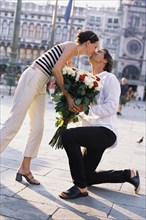 Man giving girlfriend flowers in St. Mark's Square