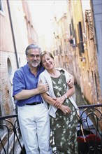 Senior couple hugging over urban canal