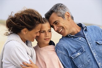 Caucasian family hugging on beach