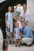 Caucasian family waving from doorway