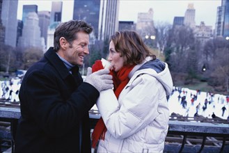 Couple sharing coffee outside Rockefeller Center