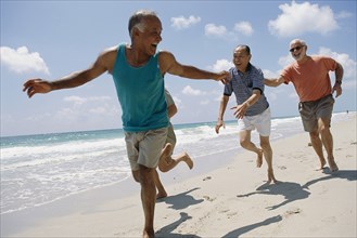 Senior friends jogging on beach