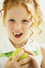 Smiling girl eating apple