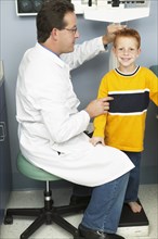 Doctor measuring boy's height in office