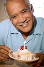 Senior man eating birthday cake