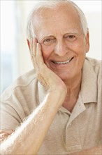 Senior man resting chin in hand