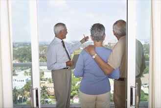 Realtor showing senior couple view from balcony
