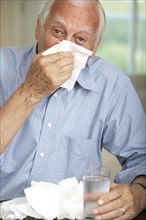 Senior man wiping his nose