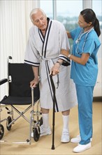 Nurse helping Senior patient use cane