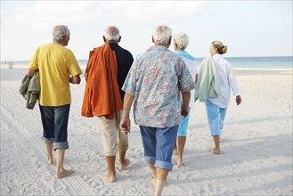 Senior friends walking on beach