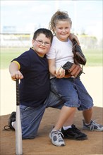 Children smiling together on baseball diamond
